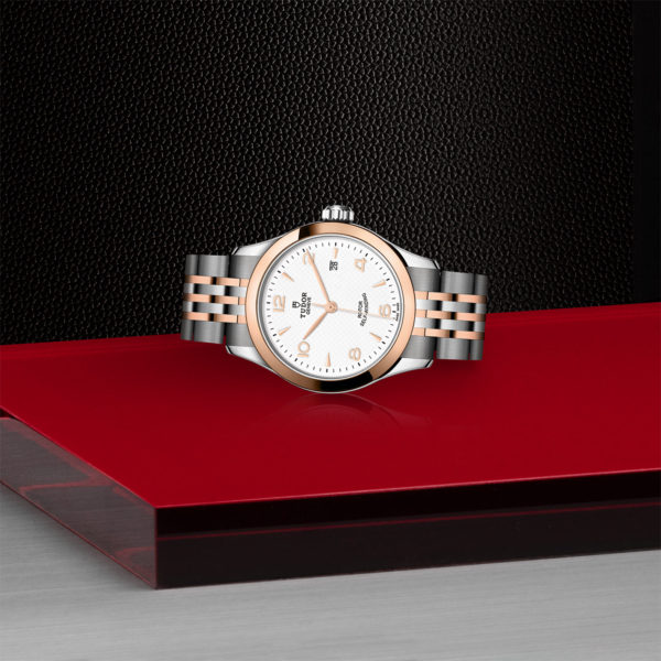 TUDOR 1926 Watch with a 28mm Steel Case, Rose Gold Bezel (M91351-0009) Laying Down on Red Tray