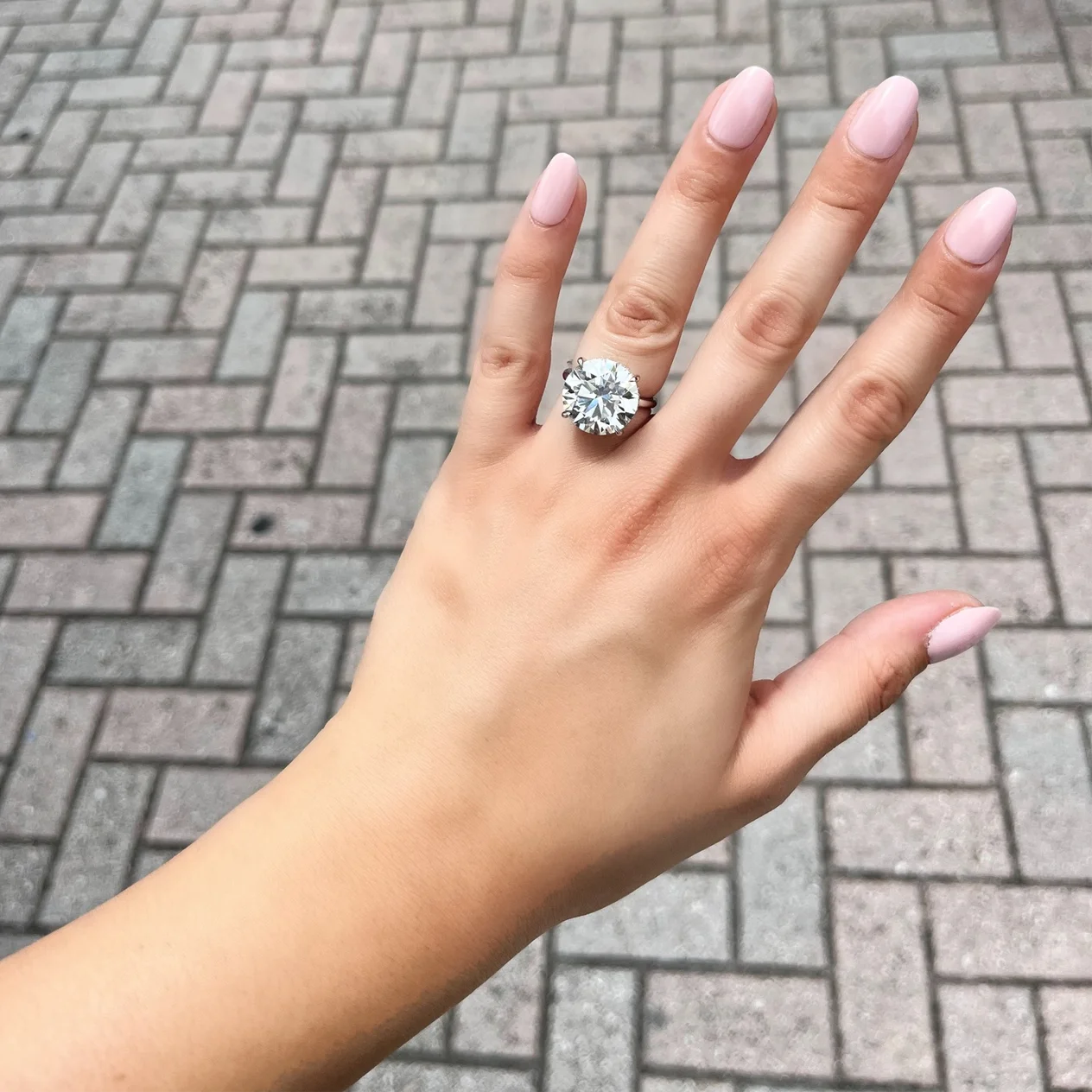Round diamond solitaire engagement ring on finger