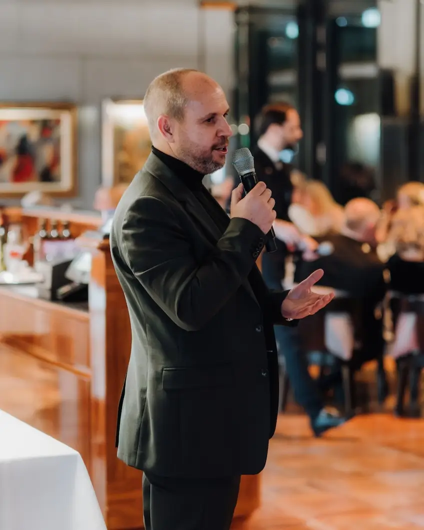 man speaking into microphone at event