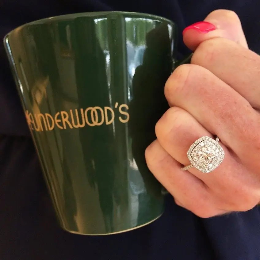 diamond ring on model's finger while holding Underwood's mug
