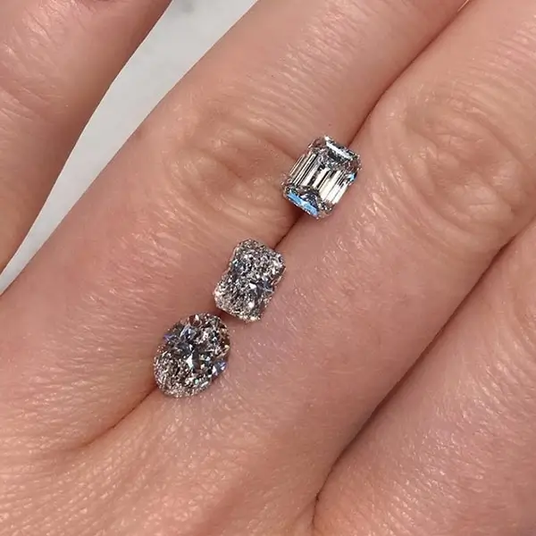 3 loose diamonds between model's fingers