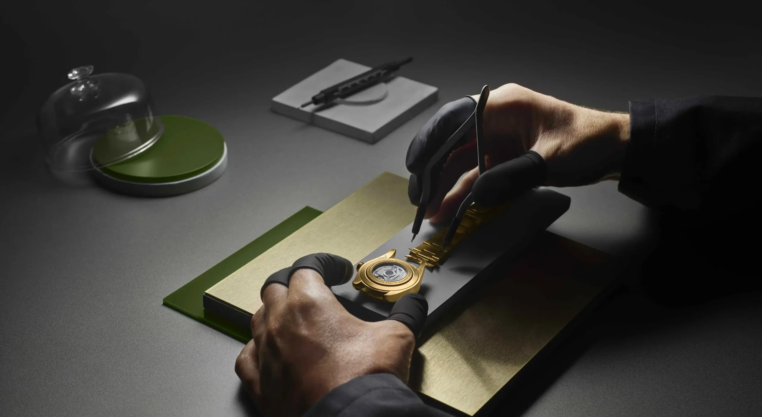 Watchmaker assembling a TUDOR watch using tweezers