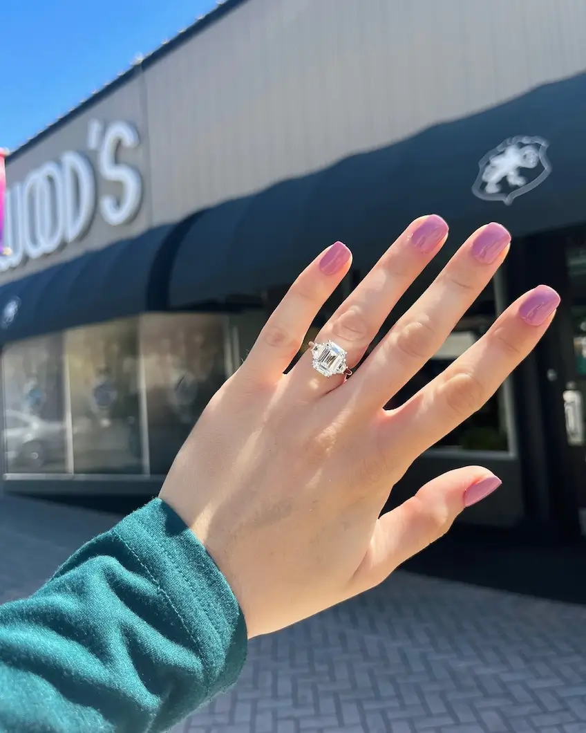 diamond engagement ring on woman's ring finger, Underwood's storefront in background