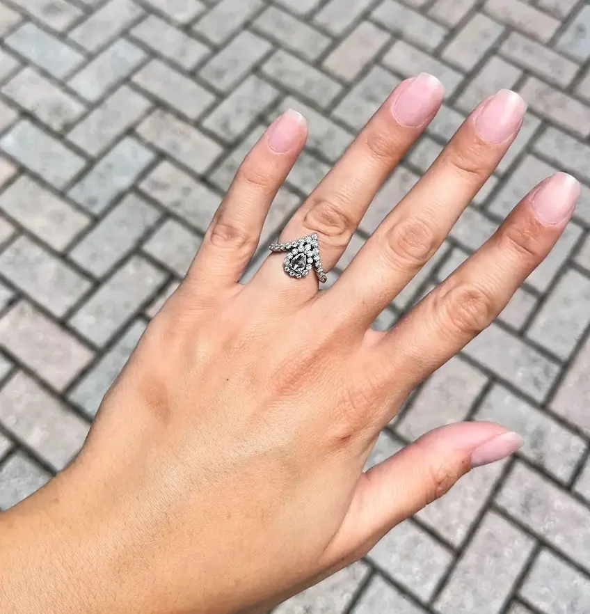 Unique pear shaped engagement ring on woman's ring finger