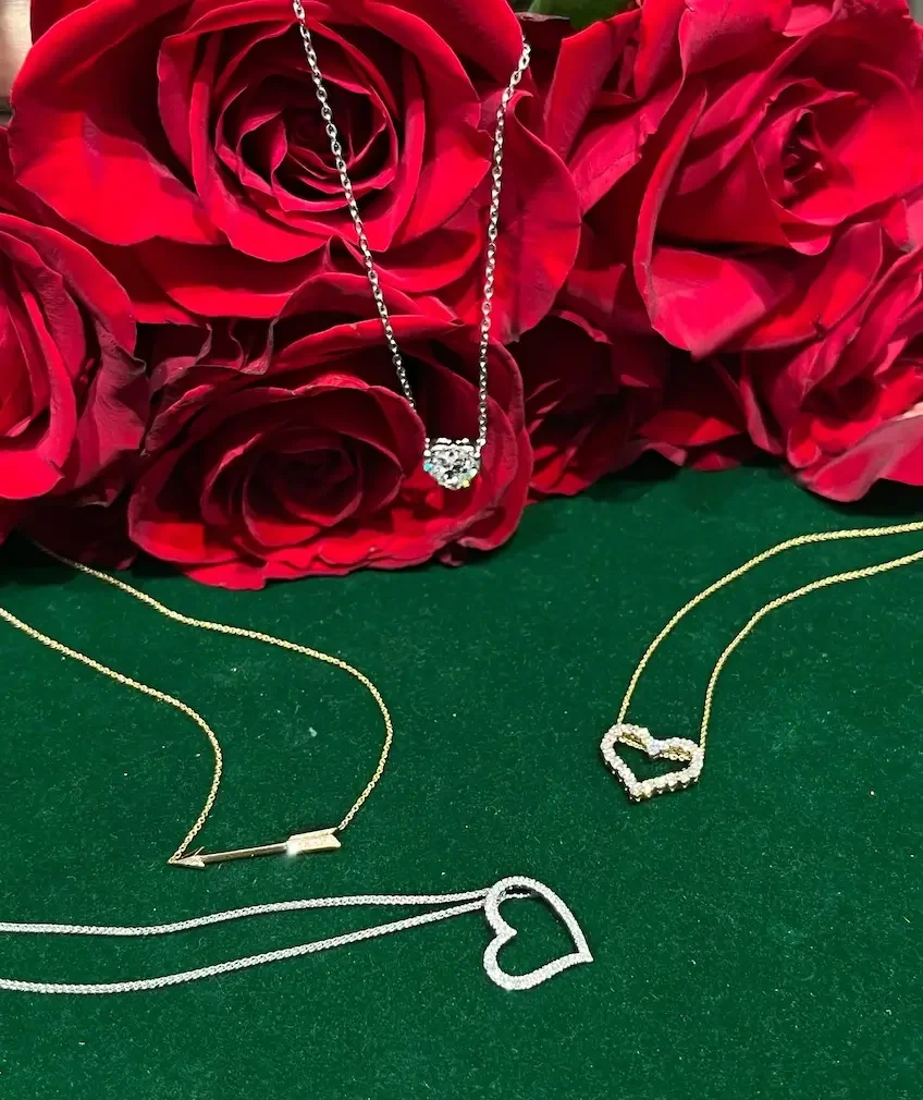 Underwood's Valentine's Day necklaces displayed, red roses in background