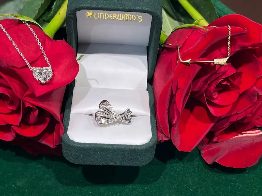 Underwood's diamond jewelry pieces, bow ring in green velvet box with red roses