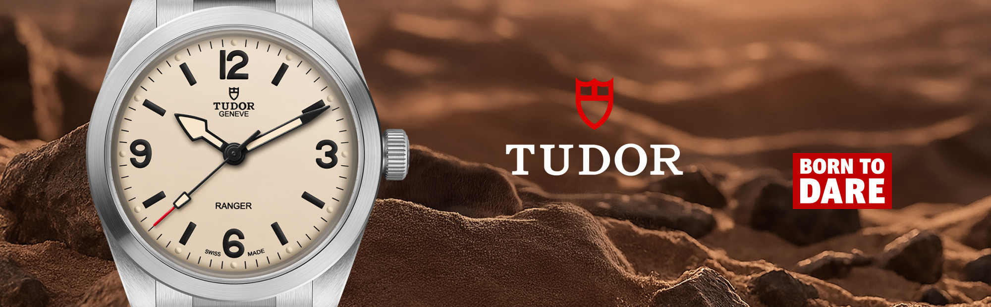 TUDOR Ranger watch featuring a cream dial, bold black Arabic numerals, stainless steel case and bracelet, displayed against a rugged mountain landscape with the TUDOR and Born to Dare logos.